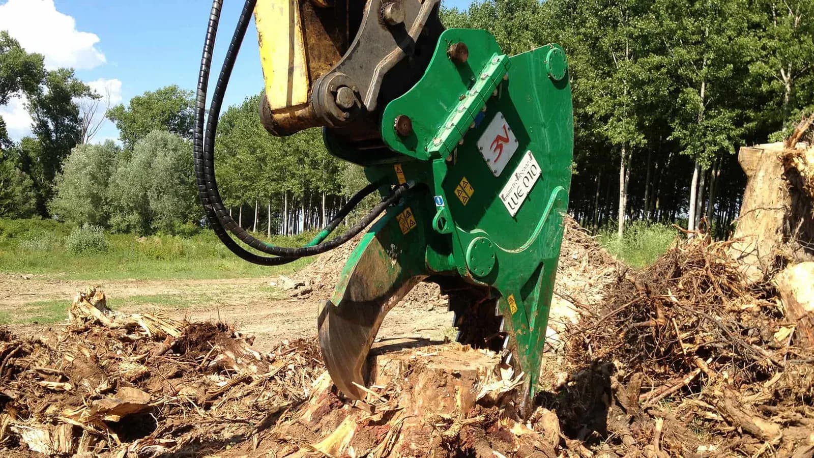 Trevi Benne WE 010 stump cutter closing its toothed jaw on an extracted stump, surrounded by split timber and root debris